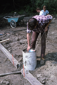 Moon Barn site preparation at entrance of Hopkins Forest. Tom Kalt adjusting level of concrete in sonotubes for post footings.