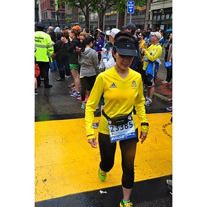Woman in Boston Athletic Association shirt crosses One Run finish line