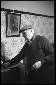 Portrait of an older man, standing by a side table in a Scottish pub