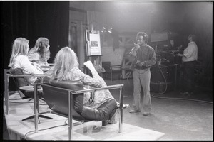 Commune members at the WGBY Catch 44 (public access television) interview: shot from the rear of Jim Baker, Bruce Geisler, and Anne Baker (l. to r.) on stage