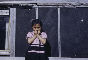 Young girl posing outside her house