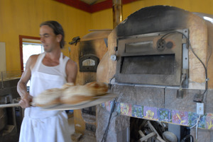 Hungry Ghost Bread: owner and baker Jonathan C. Stevens removing loaves of bread from the oven