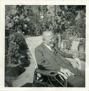 W. E. B. Du Bois sitting in a wicker chaise longue in a garden in Hampstead