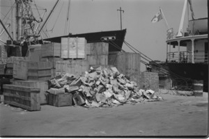 Empty cases of pilfered crates of condensed milk on port; Saigon.