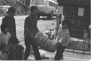 Bag of American rice is carried home by Vietnamese family.