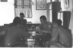 Vietnamese officers playing cards, and playing guitar while singing; Mekong Delta.