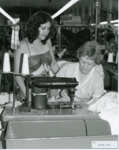 Photograph of two women at a table with a Singer sewing machine, [1982-1983].