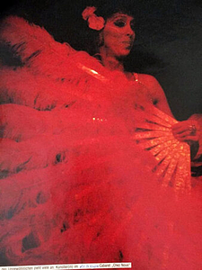 A Photograph of Marlow Monique Dickson Posing Behind a Feather Fan