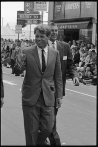Robert F. Kennedy walking down the street at the Turkey Day parade while stumping for Democratic candidates in the northern Midwest
