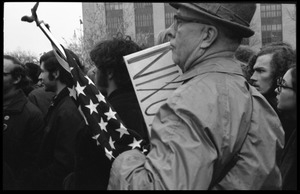 Counterprotester with an American flag and pro-Nixon sign during the Counter-inaugural demonstrations, 1969, against the War in Vietnam