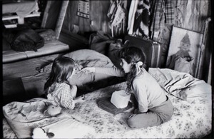 Two young girls playing on a bed
