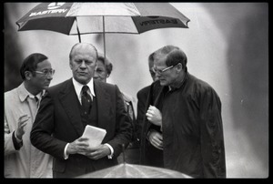 Gerald Ford at the dedication of the Old Great Falls Historic District as a national historic landmark, walking under an umbrella with entourage