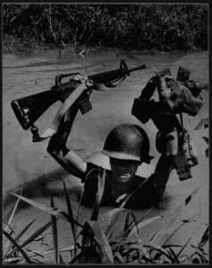 Teenage ARVN recruit fords a stream