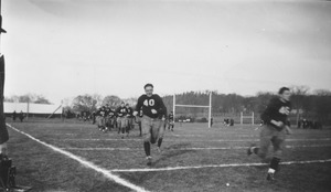 Football players running onto the field prior to a campus game