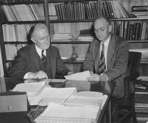 William Lawson Machmer sitting in office with gentleman looking at papers
