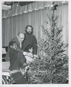 Dr. DiMichael and unidentified man decorating Christmas tree with clients