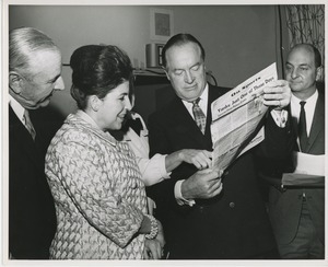 Bob Hope looking at sports section with Licia Albanese