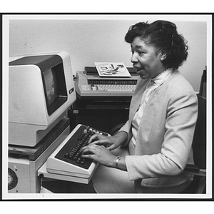 Woman sits at a computer typing