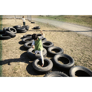 Child playing with tires on a playground