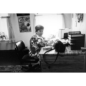 Carmen Colombani, an Inquilinos Boricuas en Acción staff member, seated at her desk in her office.
