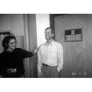 Clara Garcia and an unidentified man in front of a door with a No Smoking sign.
