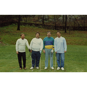 A four-man golf team posing on the golf course at a Boys and Girls Club Golf Tournament