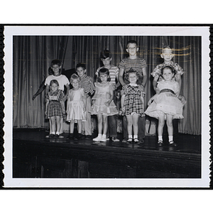 Five girls and their brothers standing together on the stage during a Boys' Club Little Sister Contest