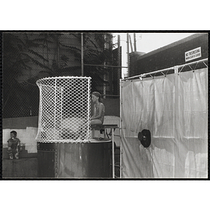 A girl sits in a dunk tank at a carnival