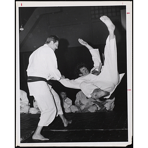 Black belt John W. Sullivan throws orange belt John Cloherty in a martial arts demonstration at Thompson Academy