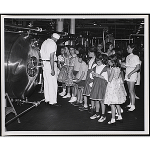 A group of girls listen to an employee as they tour a Hood dairy plant during a day camp event