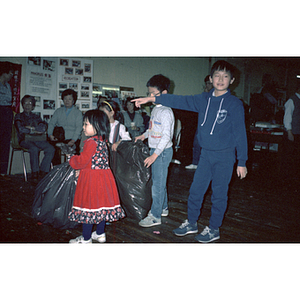 Children hold trash bags at a Garment Workers' Center event