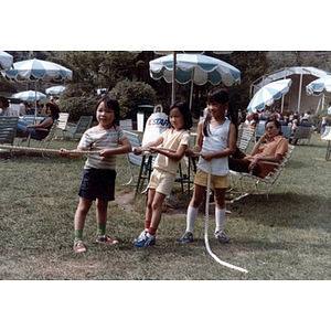 Young girls get ready to play tug-of-war in a picnic area