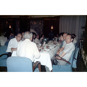 Association members sit at a dinner table during a banquet