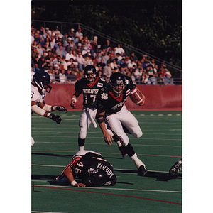 Three Northeastern football players in action on the field during a game