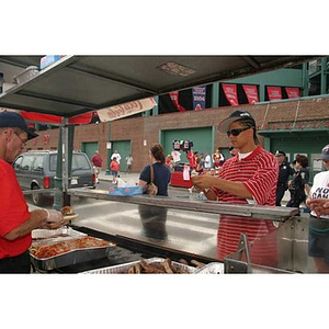 Danny Vazquez waits for food at a stand outside Fenway Park