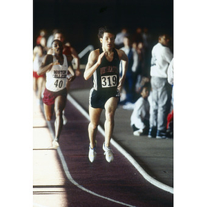 A Northeastern student, number 319, from the men's indoor track and field team competing in the Greater Boston Championships at Harvard