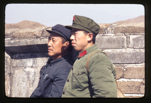 People's Liberation Army soldier and friend on Great Wall, graffiti on walls