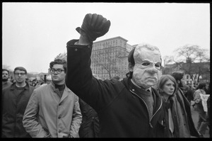 Anti-Vietnam War protester in a paper mache Nixon mask, raising his fist, during the Counter-inaugural demonstrations, 1969