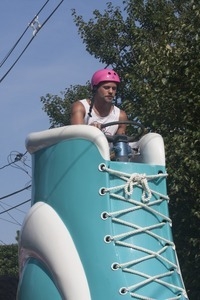 Parade marchers on a float, driving a large shoe : Provincetown Carnival parade