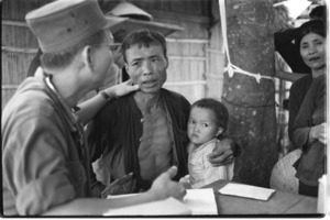 Vietnam army doctor giving treatment to Vietnamese peasants at Binh Gia.