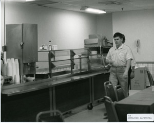 Photograph of cafeteria serving area and tables, [1982-1983].