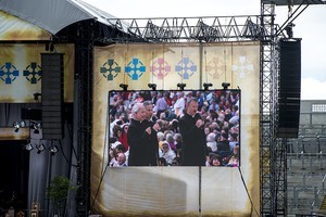 The altar on the large stage, with screens at either side showing The Priests (three priests from Northern Ireland) singing, at the 2012 50th Eucharistic Congress, Final Day Ceremony, 17th June, at Croke Park GAA Stadium, Dublin