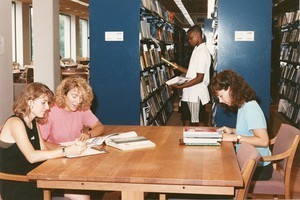 O'Neill Library interior: students studying at table and browsing the stacks