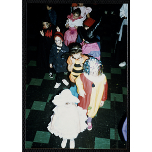 Children in costumes stand in line at a Halloween party