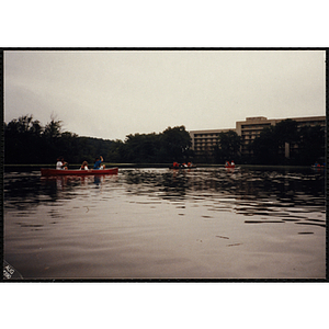 A group of youth and their supervisors paddle canoes