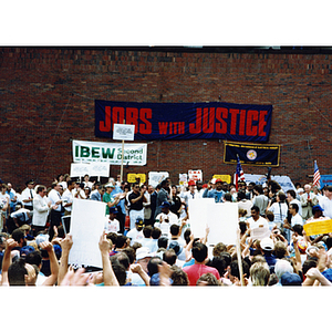 Crowd applauds as Jesse Jackson, the leader of the Rainbow Coalition, and Jan Pierce, Vice President of the Communication Workers of America, stand before the striking NYNEX workers and supporters at a rally at City Hall Plaza, Boston