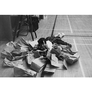 Boston-Bouvé College student lays on the floor in a pile of paper bags during a workshop on social recreation