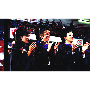 Three students applauding for speaker at Law School commencement