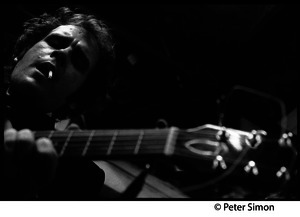 Tim Hardin playing guitar and smoking at the Unicorn Coffee House, Boston, Mass.