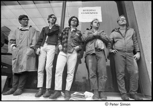 MIT war research demonstration: demonstrators standing by a window outside a building